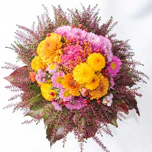 Herbstlicher Blumenstrauß mit rosa und gelb Chrysanthemen, Astern, Heidekraut und Ahorn-Blättern für Blumenlieferung Nidderau