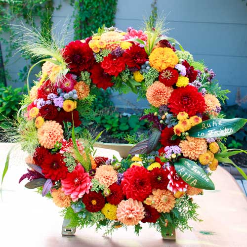 Sommerlicher herbstlicher Trauerkranz mit Aufstellerfuß mit roten und orange Dahlien in Nidderau